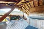 Enjoy breathtaking mountain views from this stunning property featuring a private hot tub and a spacious wooden deck.