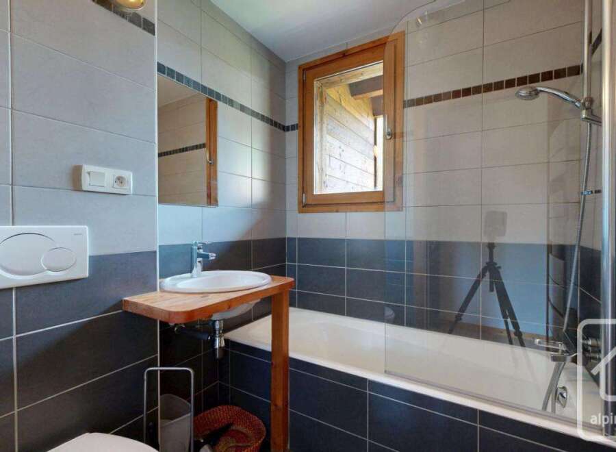 This modern bathroom features a sleek design with gray and black tiles, creating a sophisticated ambiance.