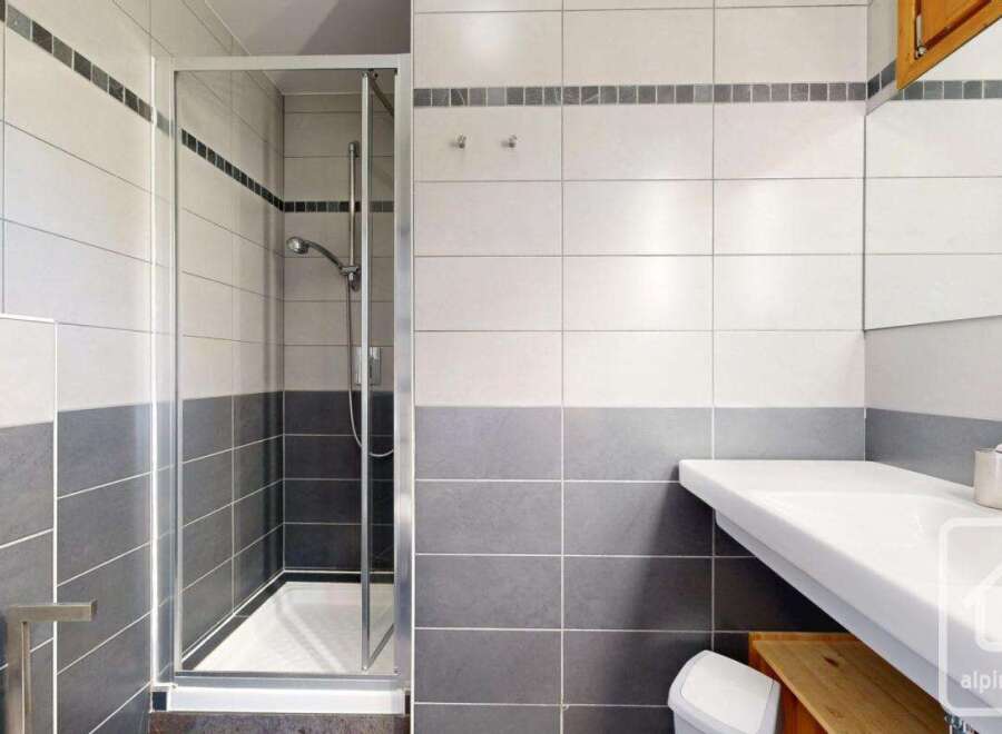 This modern bathroom features a sleek glass shower enclosure, perfect for a refreshing start to your day.