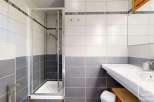 This modern bathroom features a sleek glass shower enclosure, perfect for a refreshing start to your day.