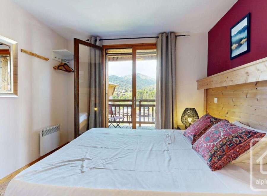 Experience the charm of this cozy bedroom, featuring a comfortable bed and a stunning mountain view from the balcony.