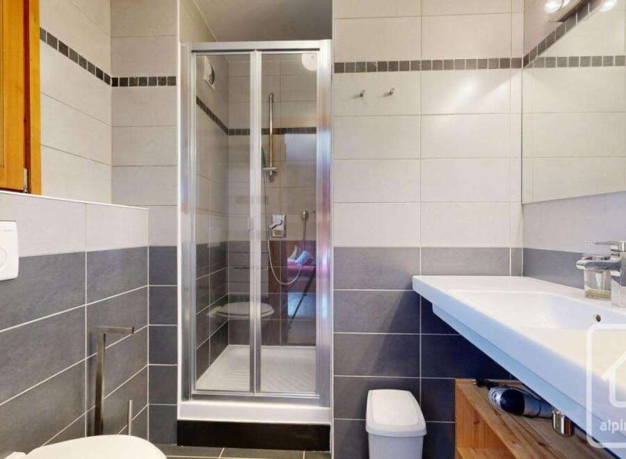 This modern bathroom features a sleek glass shower, a stylish sink, and a clean, minimalist design.