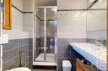 This modern bathroom features a sleek glass shower, a stylish sink, and a clean, minimalist design.