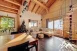 Discover the charm of this stunning chalet, featuring a cozy living area with a modern spiral staircase.