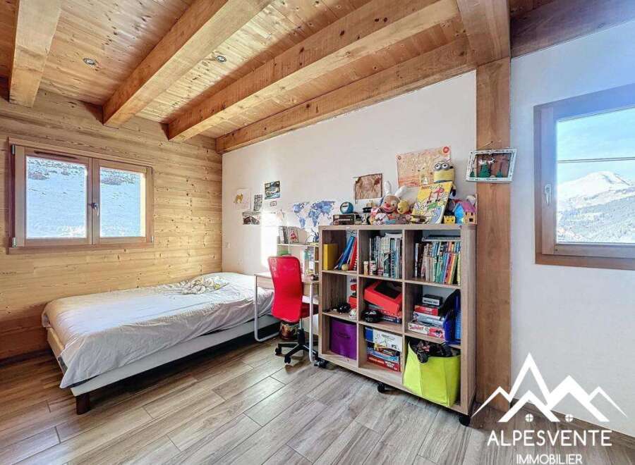 Discover the charm of this cozy bedroom featuring a wooden ceiling and walls, creating a warm and inviting atmosphere.