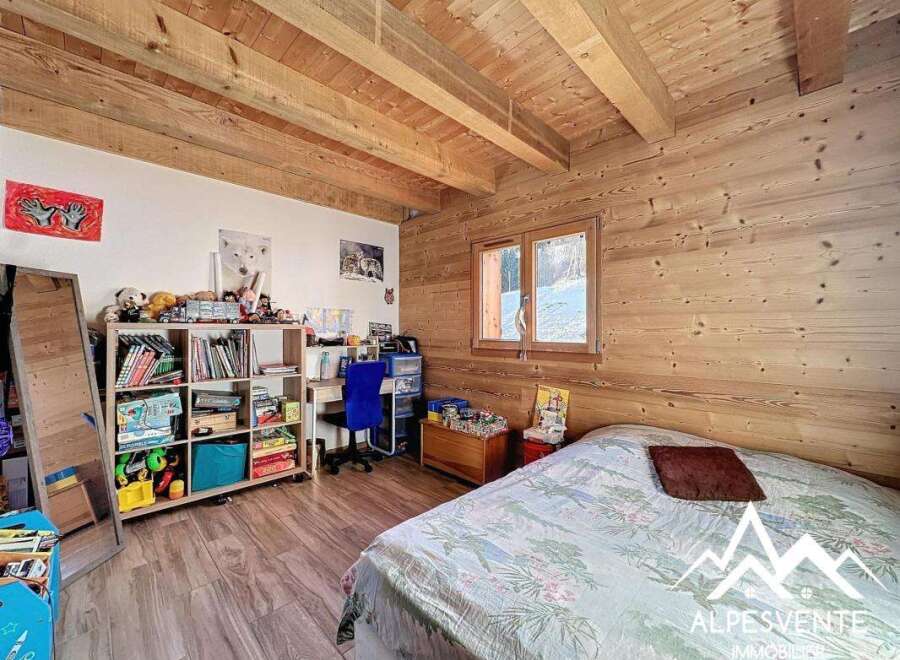 Discover the charm of this cozy bedroom featuring wooden accents and a warm ambiance.