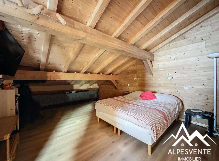 Discover the charm of this cozy bedroom featuring a rustic wooden ceiling and walls, creating a warm and inviting atmosphere.