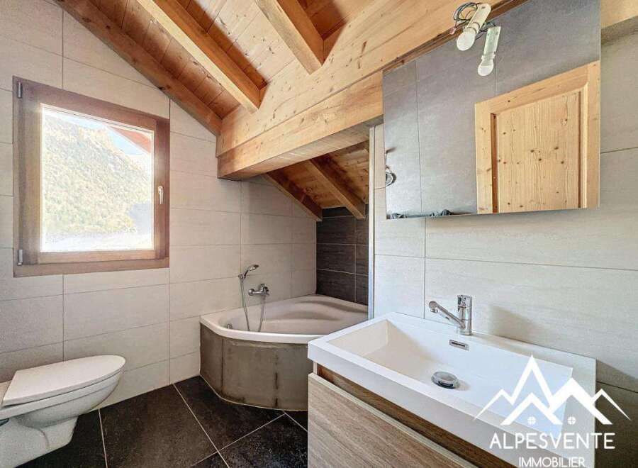 This stunning bathroom features a unique design with exposed wooden beams and a modern sink.