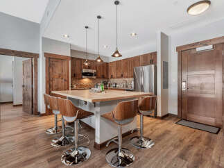 This stunning kitchen boasts a modern design with sleek wooden cabinetry and a spacious island, perfect for entertaining.