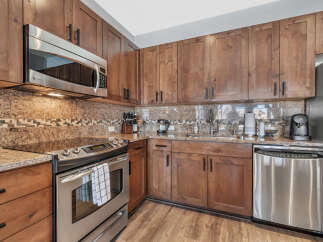 This stunning kitchen boasts beautiful wooden cabinetry and sleek stainless steel appliances, creating a warm and inviting atmosphere.