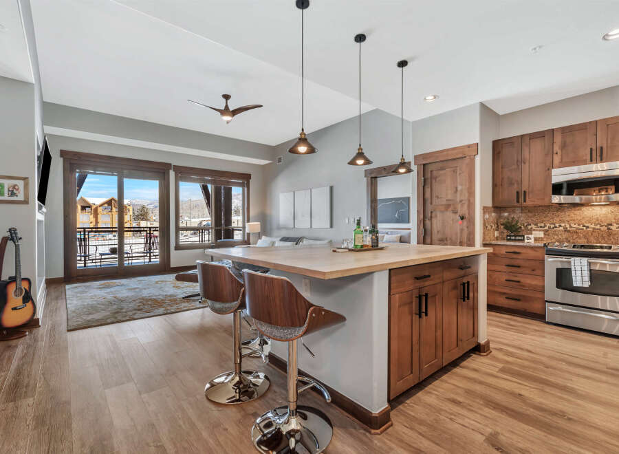 Experience luxury living in this stunning kitchen! Featuring a modern island with seating, stainless steel appliances, and beautiful wooden cabinetry.