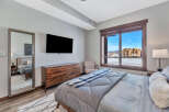 This stunning bedroom boasts a modern design with a touch of rustic charm, featuring a large window that offers breathtaking views of the surrounding landscape.