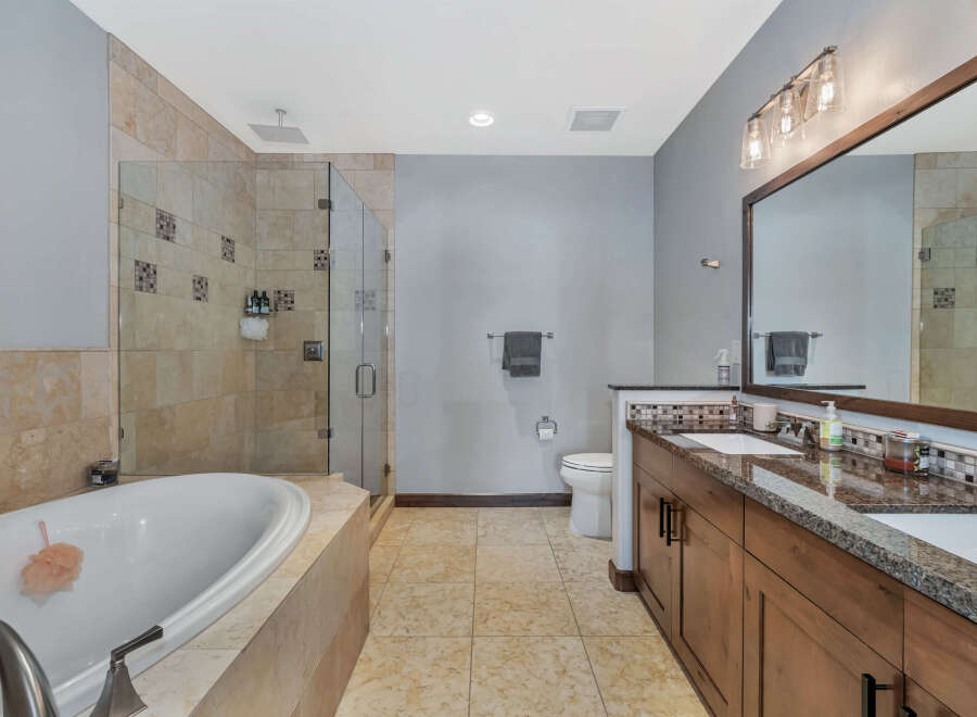 Step into luxury with this stunning bathroom featuring a spacious walk-in shower and a relaxing soaking tub.