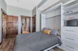 This cozy bedroom features a comfortable bed with a stylish gray comforter and decorative pillows.