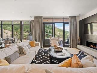Experience luxury living in this stunning property, featuring a modern fireplace and expansive windows that frame breathtaking mountain views.