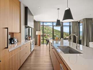 Experience luxury living in this stunning kitchen, featuring sleek cabinetry and a spacious island perfect for culinary creations.