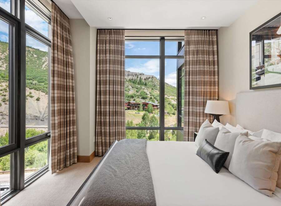 Experience luxury living with this stunning bedroom featuring breathtaking mountain views.