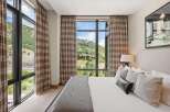 Experience luxury living with this stunning bedroom featuring breathtaking mountain views.