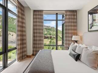 Experience luxury living with this stunning bedroom featuring breathtaking mountain views.