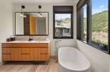 This luxurious bathroom boasts a modern design with a freestanding bathtub and a sleek double vanity.
