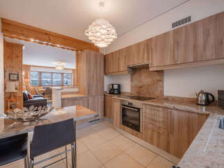 This stunning kitchen boasts a modern design with sleek wooden cabinetry and granite countertops, creating a warm and inviting atmosphere.