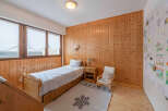 This cozy bedroom features beautiful wooden paneling and a comfortable single bed, perfect for a guest room or a child's space.