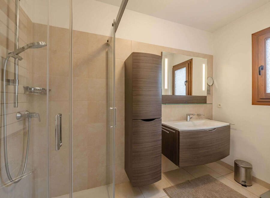 This modern bathroom features a sleek shower enclosure and stylish vanity.