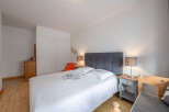 This cozy bedroom features a comfortable bed with a stylish headboard, perfect for a relaxing retreat.