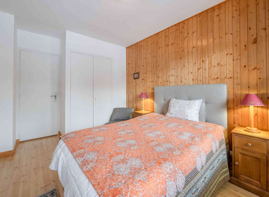 This cozy bedroom features a warm wooden accent wall, creating a welcoming atmosphere.