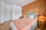 This cozy bedroom features a warm wooden accent wall, creating a welcoming atmosphere.