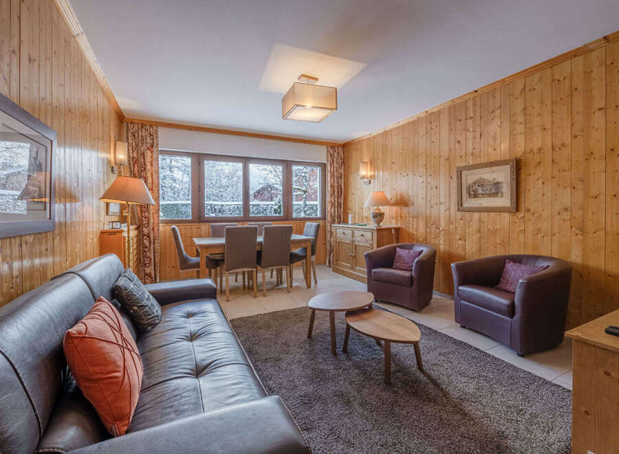 This cozy living space features a warm, inviting atmosphere with wood-paneled walls and a comfortable leather sofa.