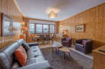 This cozy living space features a warm, inviting atmosphere with wood-paneled walls and a comfortable leather sofa.