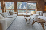 Experience breathtaking mountain views from this luxurious living room, featuring a plush sectional sofa and two cozy armchairs.
