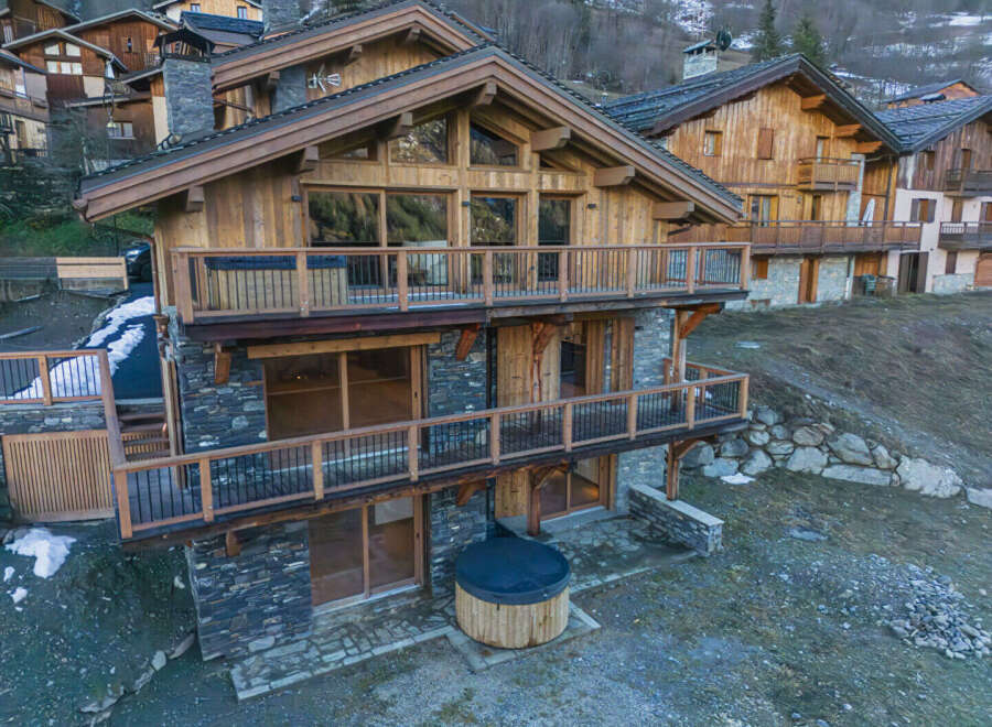 Experience luxury mountain living in this stunning chalet, featuring a private hot tub perfect for relaxing after a day on the slopes.