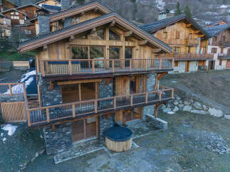 Experience luxury mountain living in this stunning chalet, featuring a private hot tub perfect for relaxing after a day on the slopes.