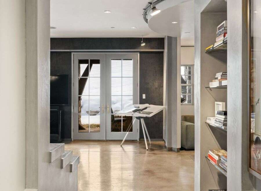 Step into modern elegance with this stunning property, showcasing a sleek hallway with polished concrete flooring.