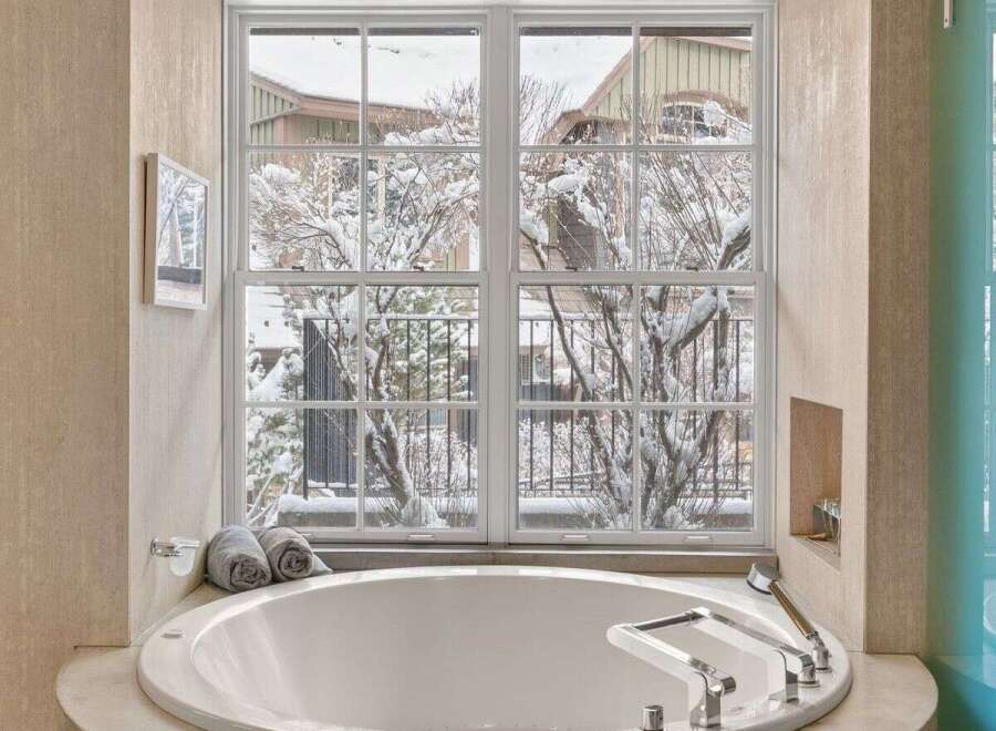 Indulge in luxury with this stunning bathroom featuring a round soaking tub, perfect for unwinding after a long day.