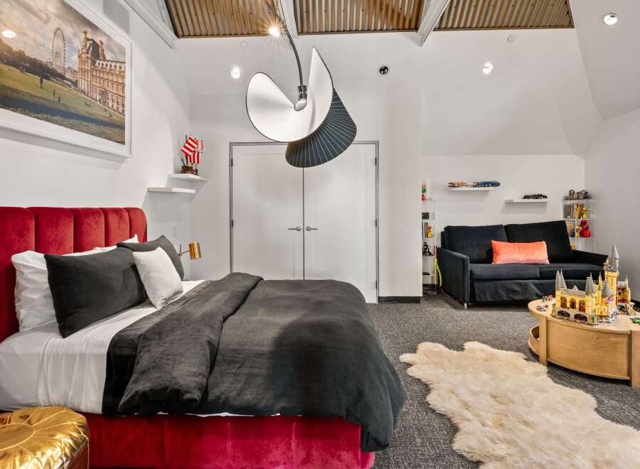 This stunning bedroom boasts a luxurious red velvet bed, creating a focal point of elegance.