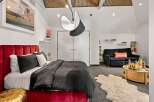 This stunning bedroom boasts a luxurious red velvet bed, creating a focal point of elegance.