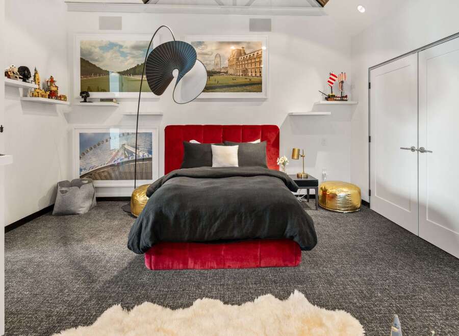 This stunning bedroom boasts a luxurious red velvet bed, creating a focal point of elegance.