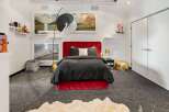 This stunning bedroom boasts a luxurious red velvet bed, creating a focal point of elegance.