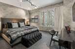 Experience luxury in this stunning bedroom featuring a plush bed with a faux fur throw and stylish accent pillows.