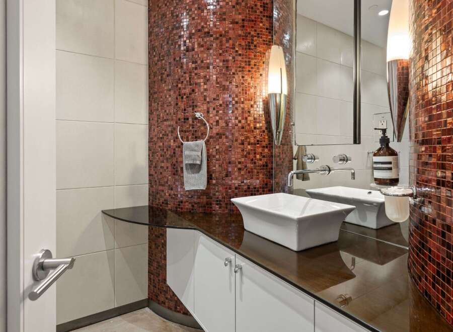 This stunning bathroom features a unique mosaic tile accent wall, adding a touch of luxury and sophistication.