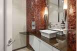 This stunning bathroom features a unique mosaic tile accent wall, adding a touch of luxury and sophistication.
