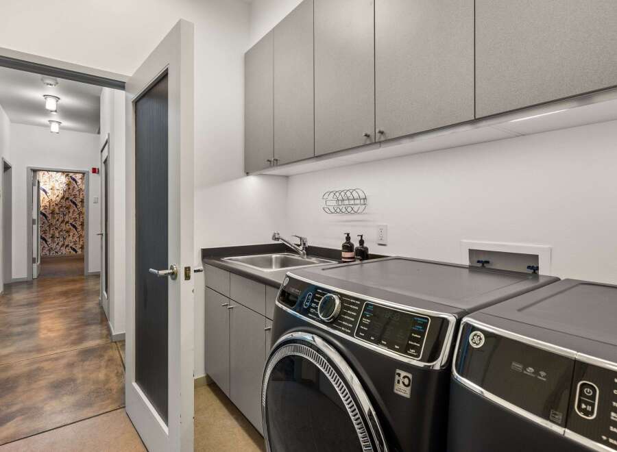 Step into modern convenience with this stylish laundry room.