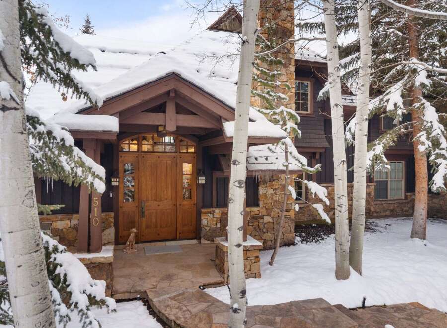 This stunning property boasts a beautiful wooden door and a charming stone facade, creating a warm and inviting atmosphere.