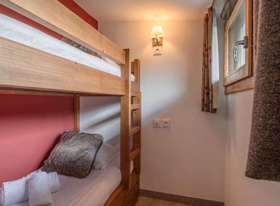 This cozy bedroom features a charming bunk bed, perfect for accommodating guests or family members.