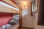 This cozy bedroom features a charming bunk bed, perfect for accommodating guests or family members.