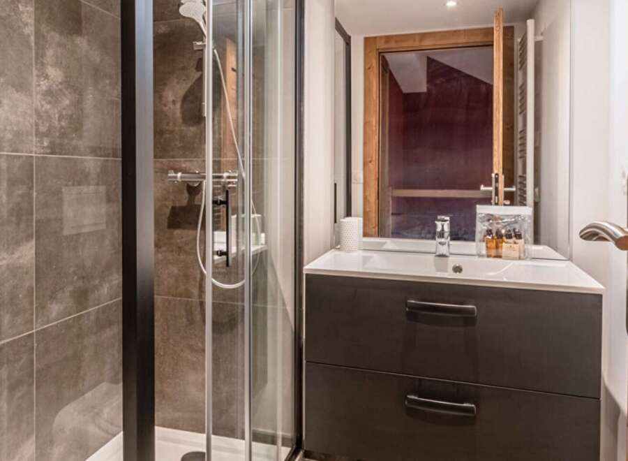 This modern bathroom features a sleek shower enclosure and a stylish vanity.