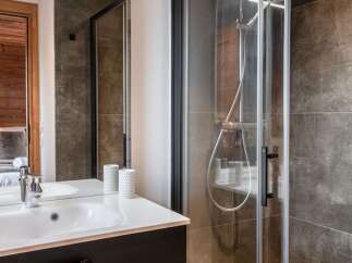 Step into luxury with this stunning bathroom featuring a sleek shower and a modern sink.